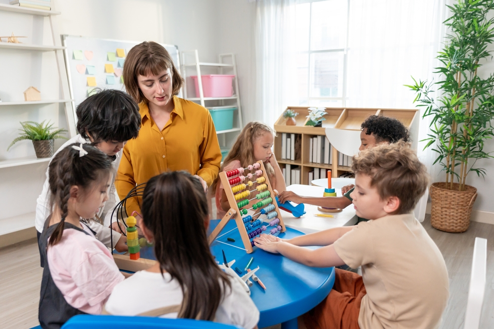 christian preschool teacher with children in classroom learning.