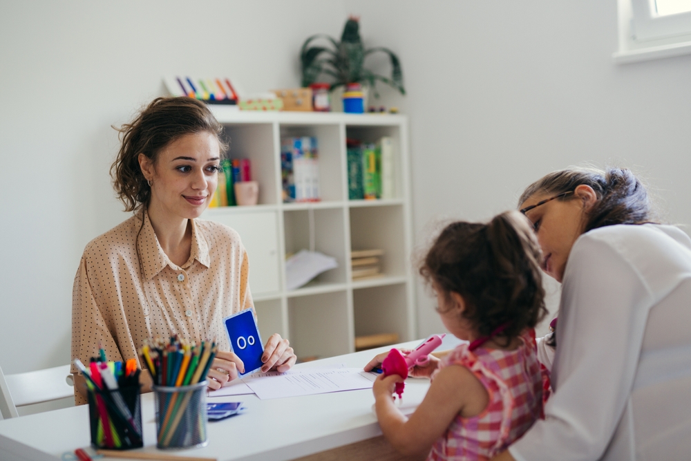 LearningLettersTogetherMotherWithDaughterAndTeacher Mother and daughter learning letters with a preschool teacher